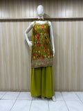 Mannequin wearing a green floral embroidered top and green pants against a striped