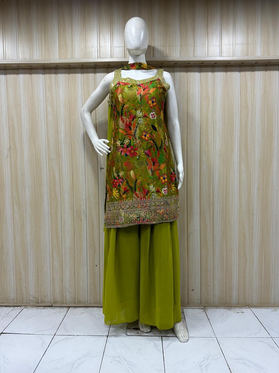 Mannequin wearing a green floral embroidered top and green pants against a striped
