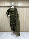 Green embroidered traditional outfit on a mannequin against a striped