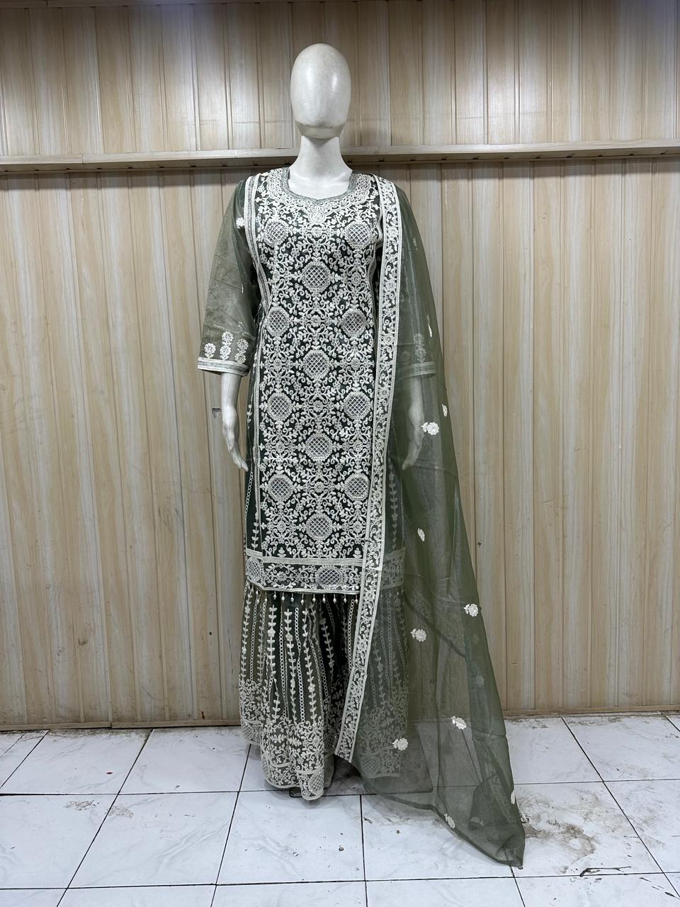 Mannequin wearing a dark -mhendi white embroidered outfit with a sheer dupatta against a striped