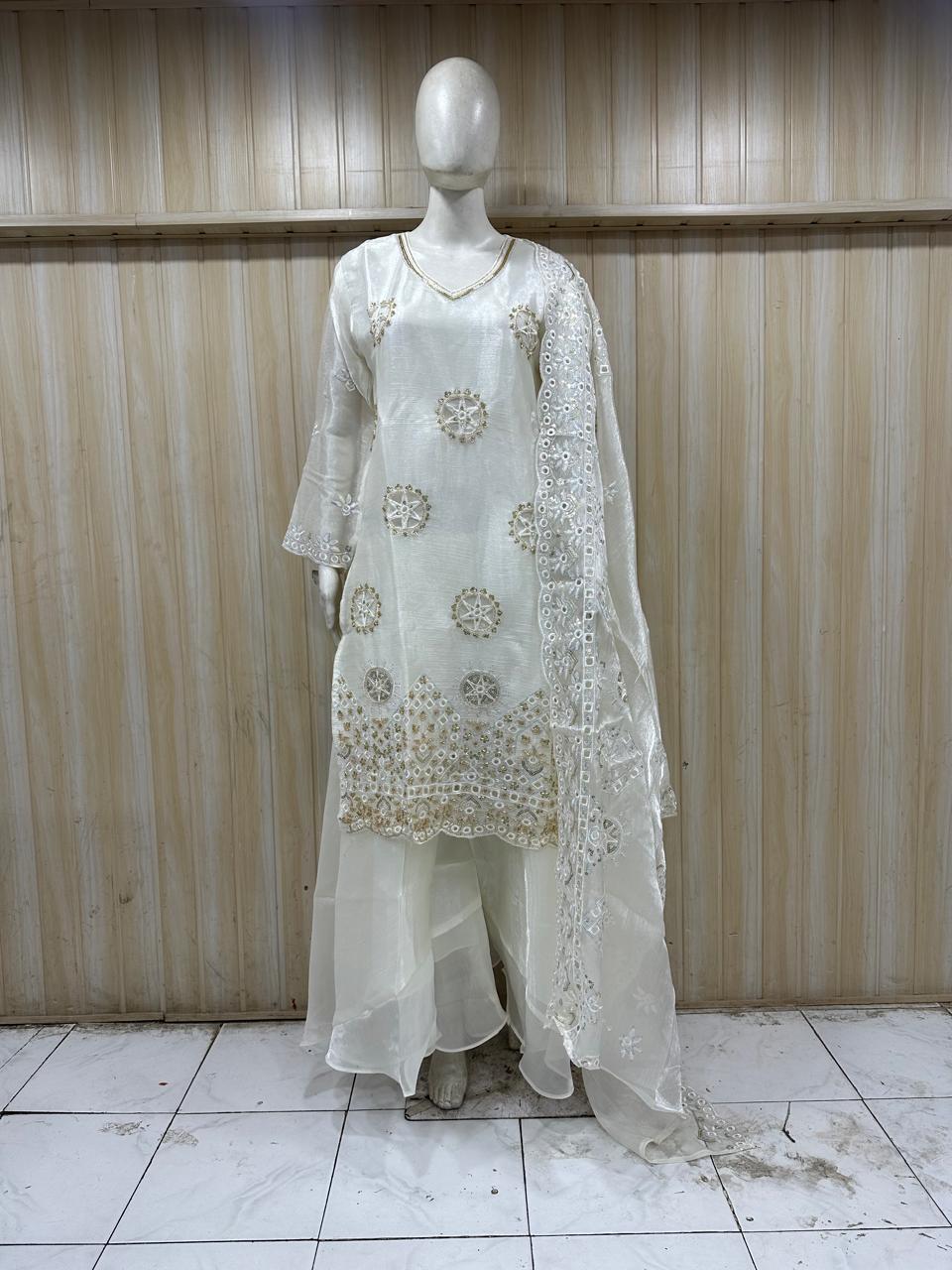 annequin wearing a white embroidered outfit against a striped