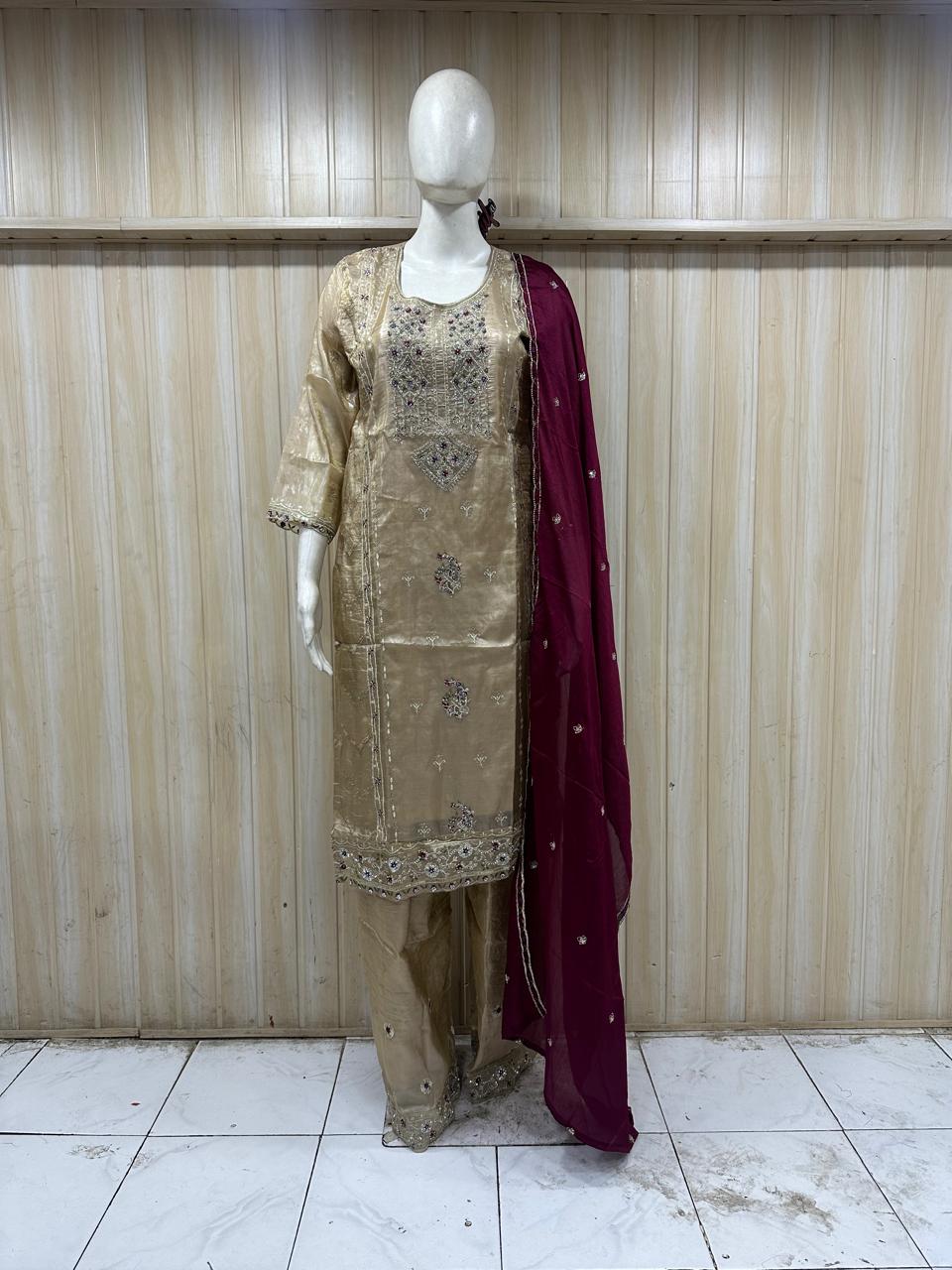 annequin wearing a maroon embroidered outfit against a striped