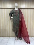 Mannequin wearing a green embroidered kurta with a red dupatta against a striped