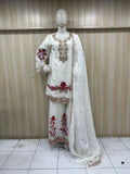 White embroidered traditional outfit with red details on a mannequin against a striped