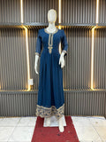 Mannequin wearing a blue dress with intricate detailing against a textured