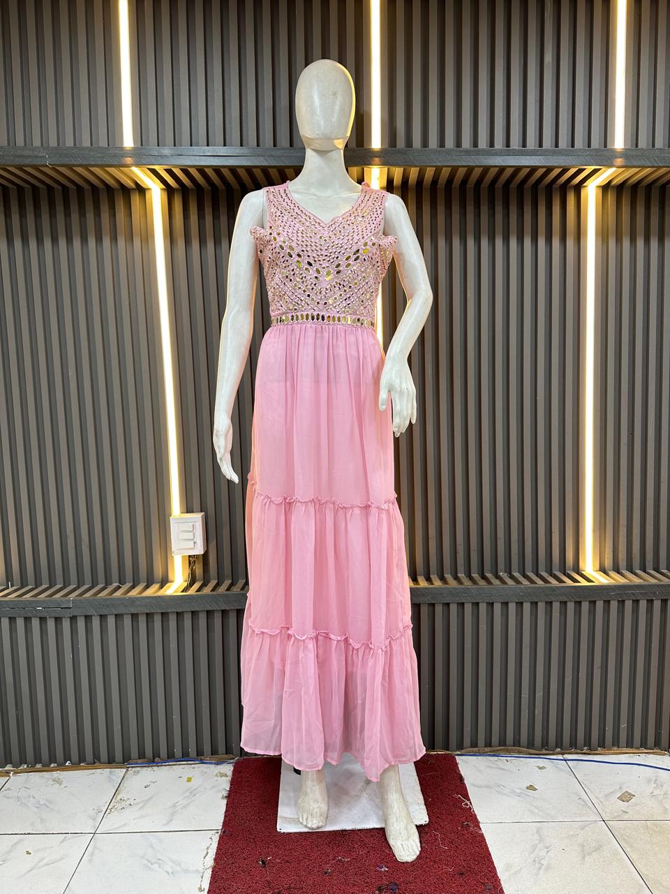 Mannequin wearing a pink dress with a textured top against a modern interior background