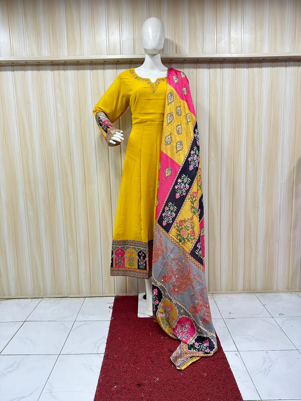 Yellow dress with a colorful dupatta on a mannequin against a striped