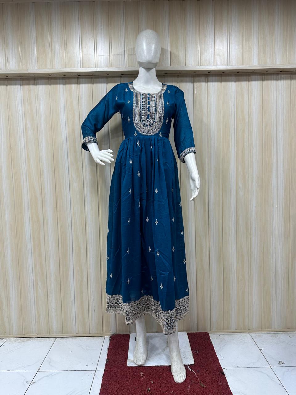 Blue embroidered dress on a mannequin against a striped