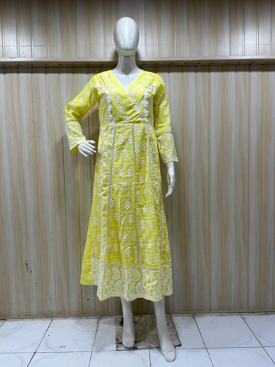 Yellow dress with floral patterns on a mannequin against a wooden panel background