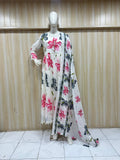 Mannequin wearing a floral dress with a matching scarf against a wooden panel background