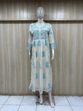 Mannequin wearing a light blue floral dress against a wooden panel background