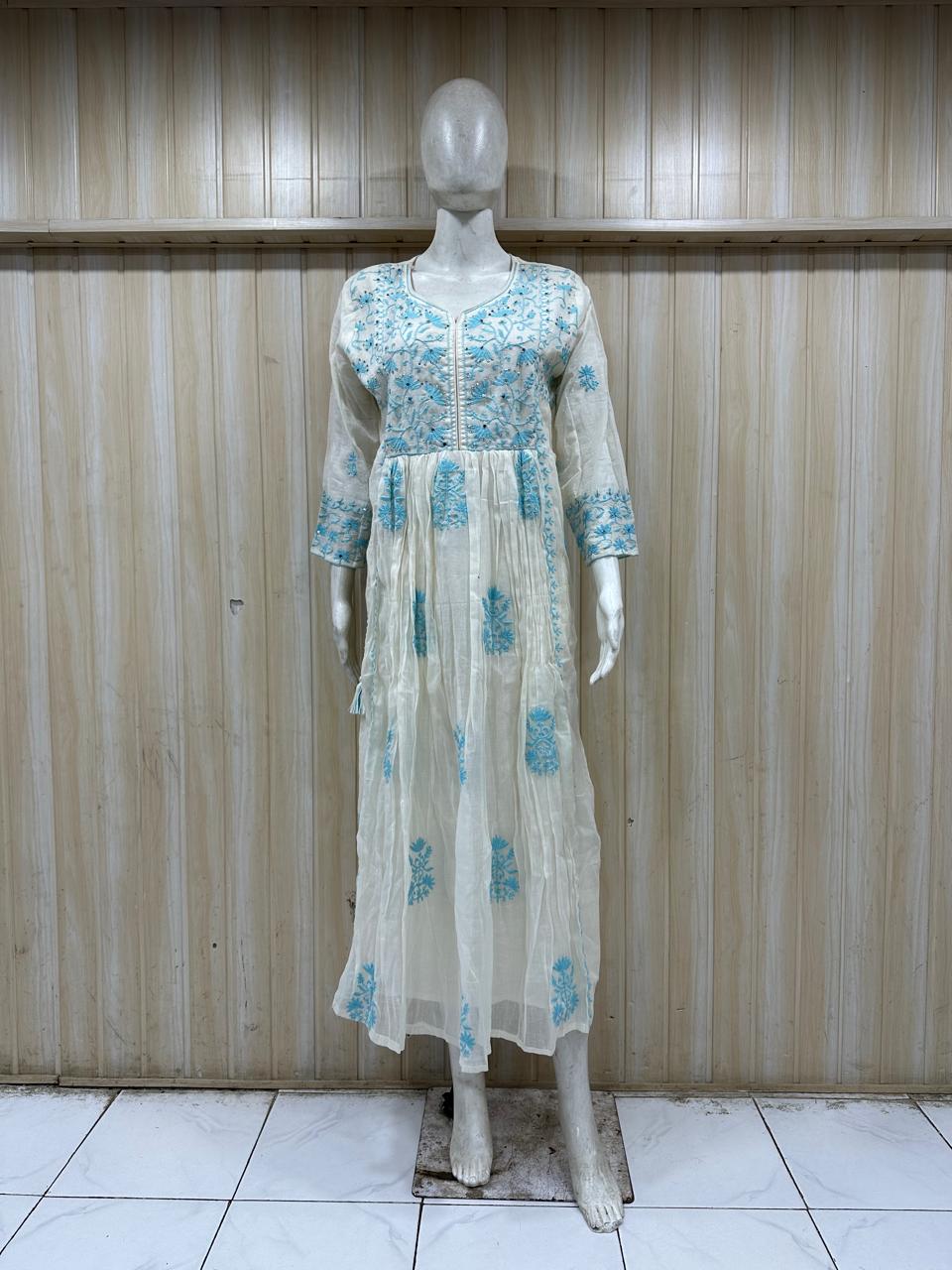 Mannequin wearing a light blue floral dress against a wooden panel background