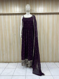 Mannequin wearing a dark purple dress with silver embellishments against a striped