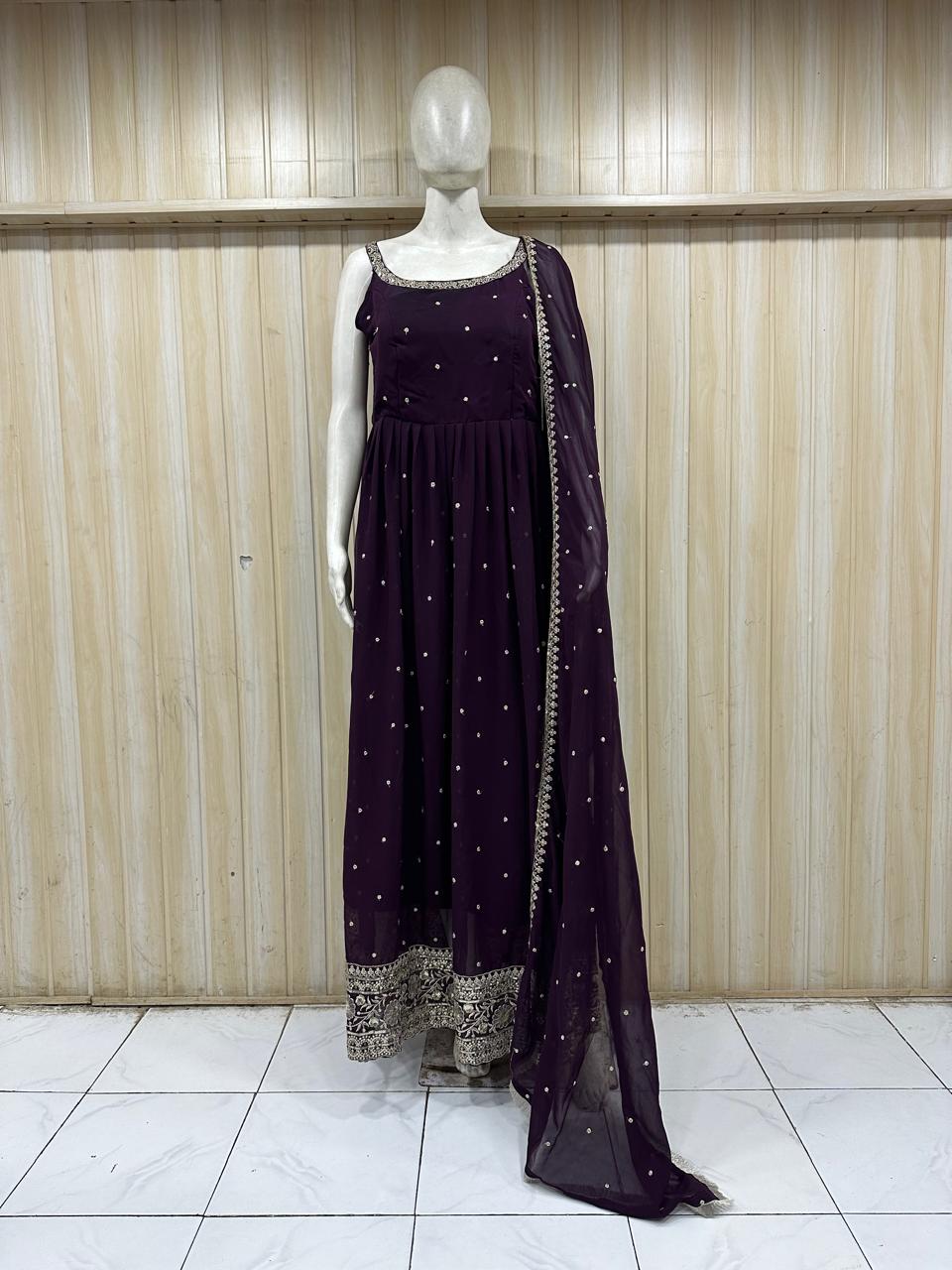 Mannequin wearing a dark purple dress with silver embellishments against a striped