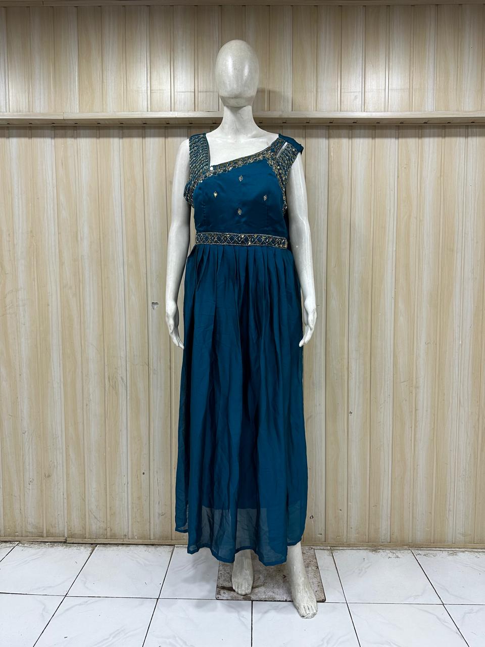 Mannequin wearing a teal dress with floral embellishments against a striped