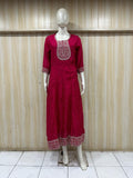 Red dress with intricate embroidery on a mannequin against a striped