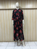 Mannequin wearing a black floral dress against a wooden panel background
