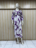 Mannequin wearing a white and purple dress against a wooden panel background