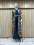 Mannequin wearing a colorful embroidered jacket over a teal dress against a striped
