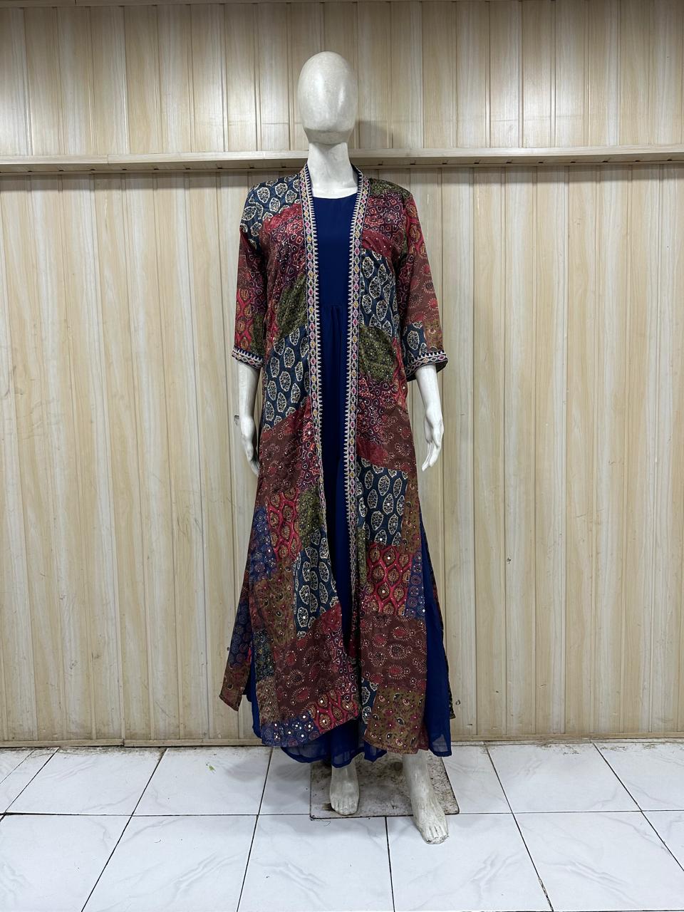 Mannequin wearing a long, patterned coat over a dark dress against a wooden panel background.