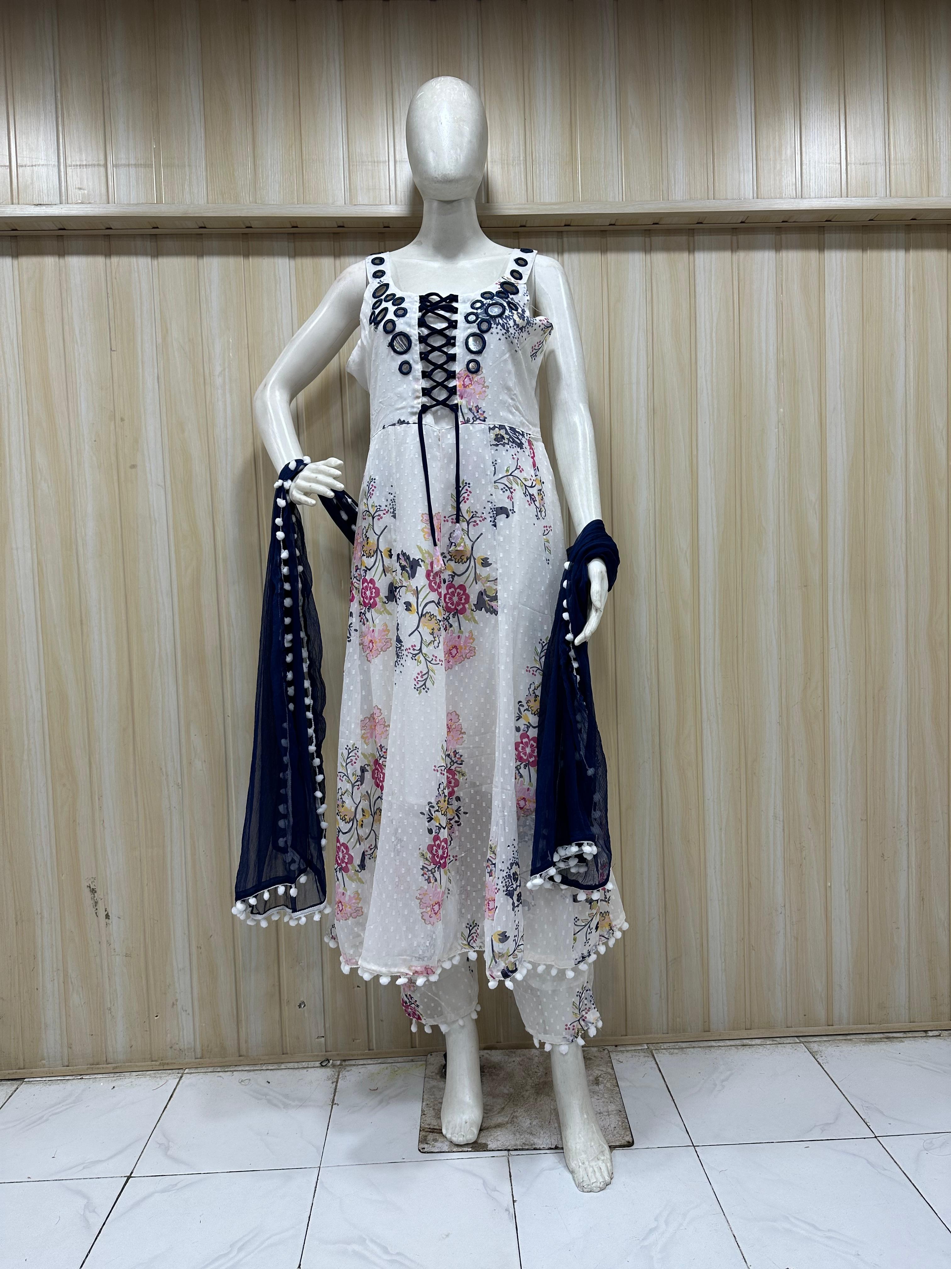 white embroidered dress with  blue matching dupatta on a mannequin against a striped