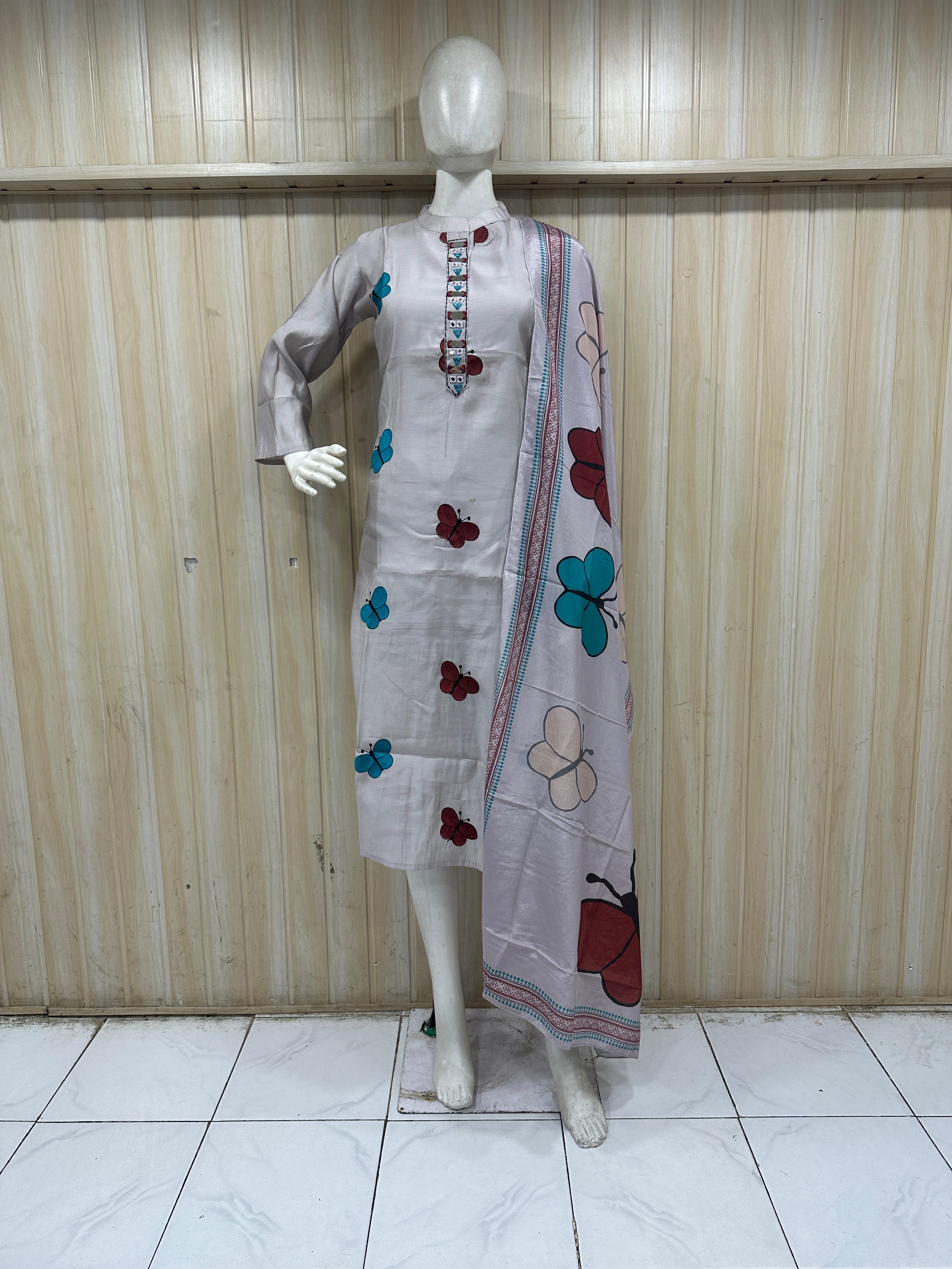 Mannequin wearing a white dress with colorful butterfly patterns against a striped