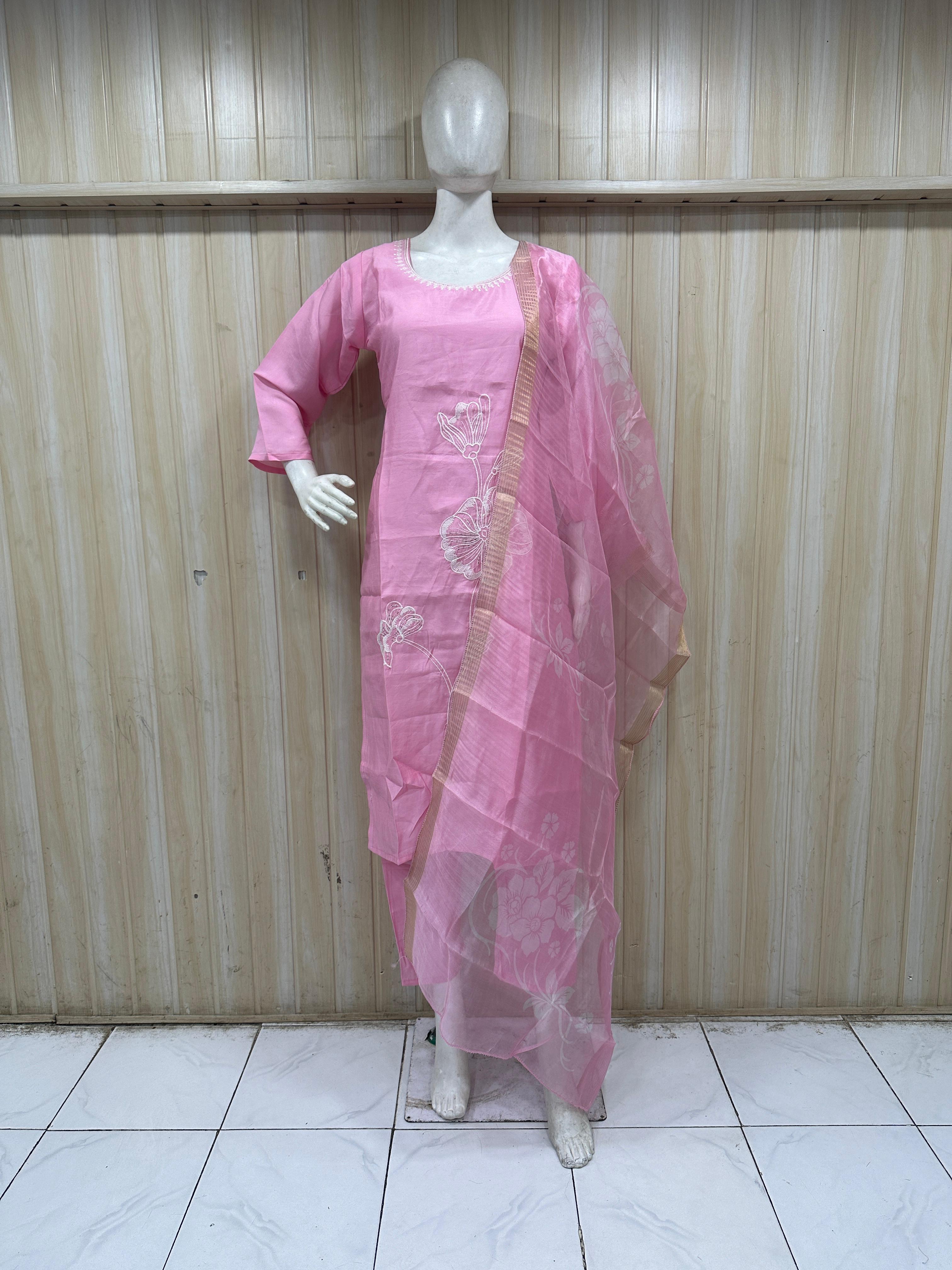 Mannequin wearing a pink traditional outfit with a saree against a striped