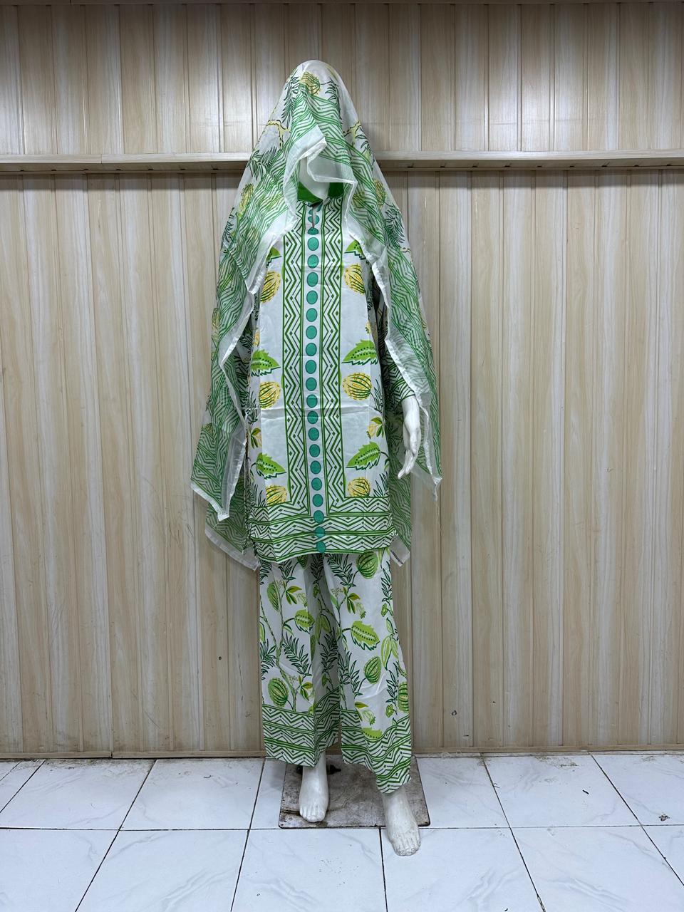 Green and white patterned outfit with a matching headscarf on a wooden background