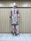 Mannequin wearing a colorful outfit with circular patterns against a striped