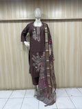 Mannequin wearing a brown embroidered dress with a matching dupatta against a striped