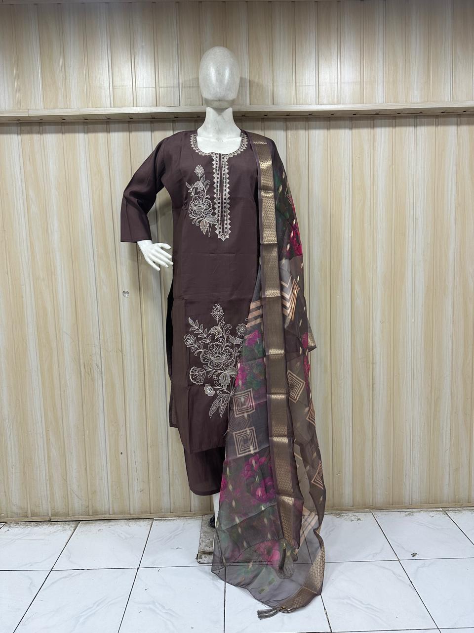 Mannequin wearing a brown embroidered dress with a matching dupatta against a striped