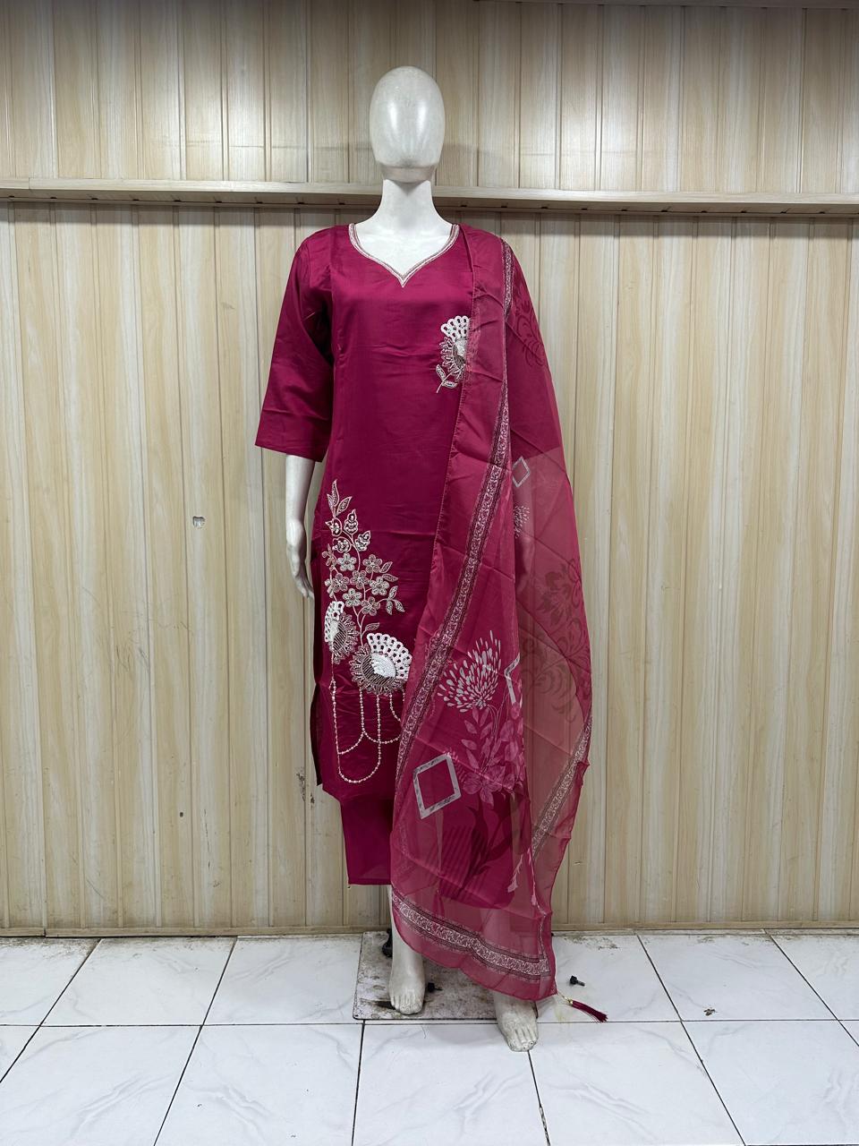 Maroon traditional outfit with floral patterns on a mannequin against a striped
