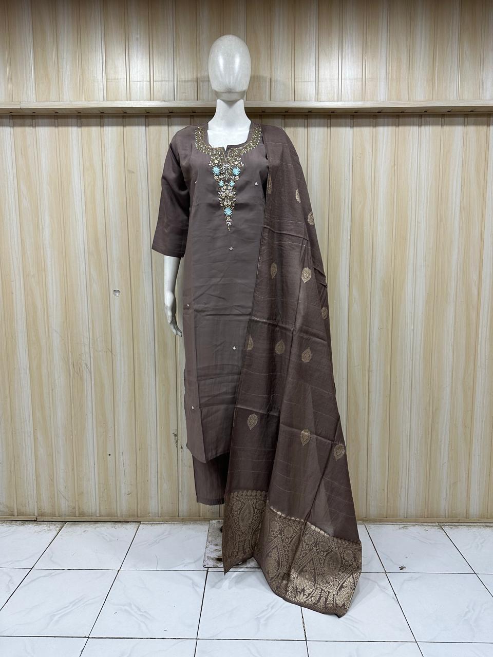 Brown traditional outfit with a saree on a mannequin against a striped