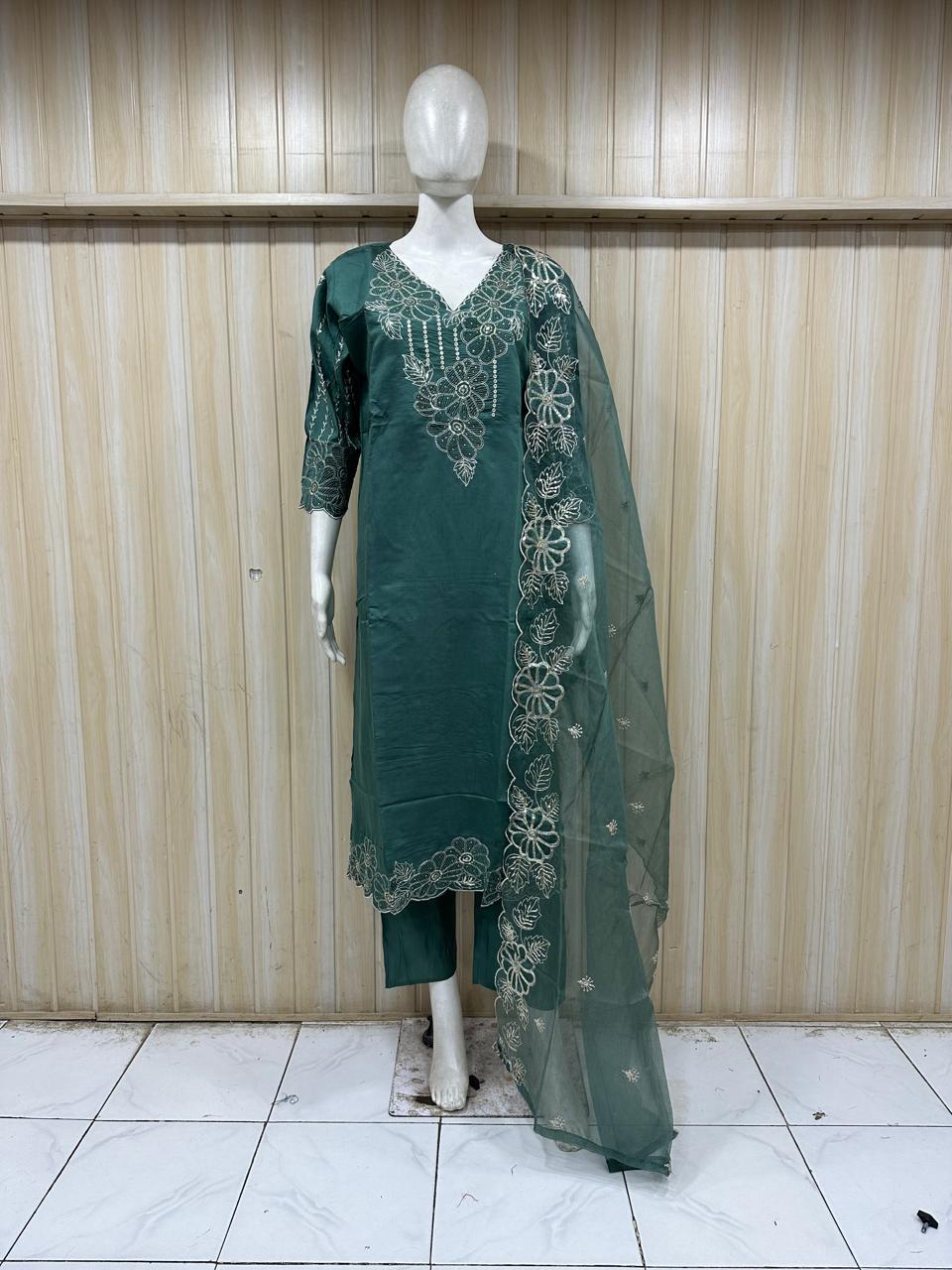 Green embroidered dress with dupatta on a mannequin against a striped