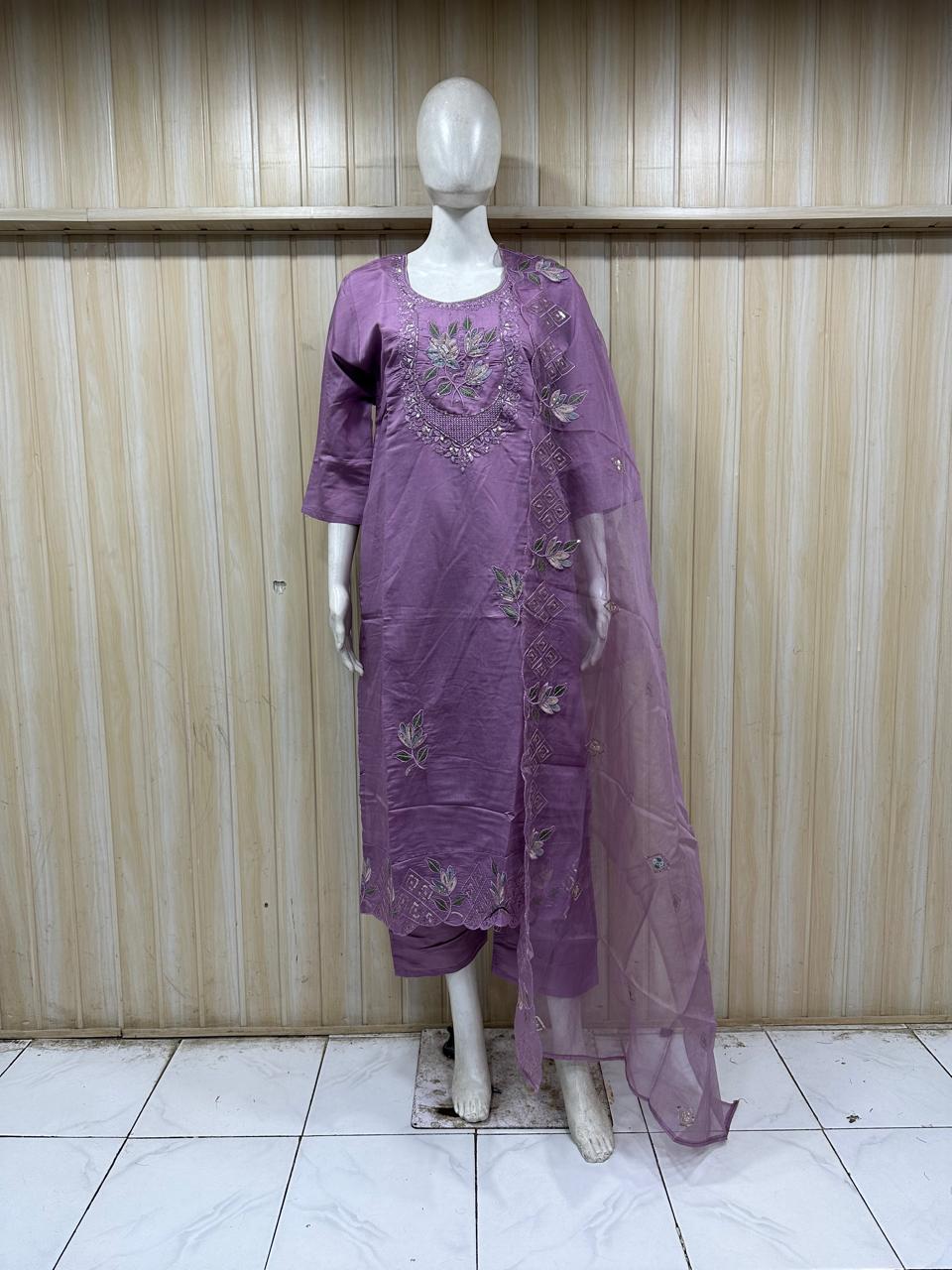 Purple embroidered outfit on a mannequin against a striped