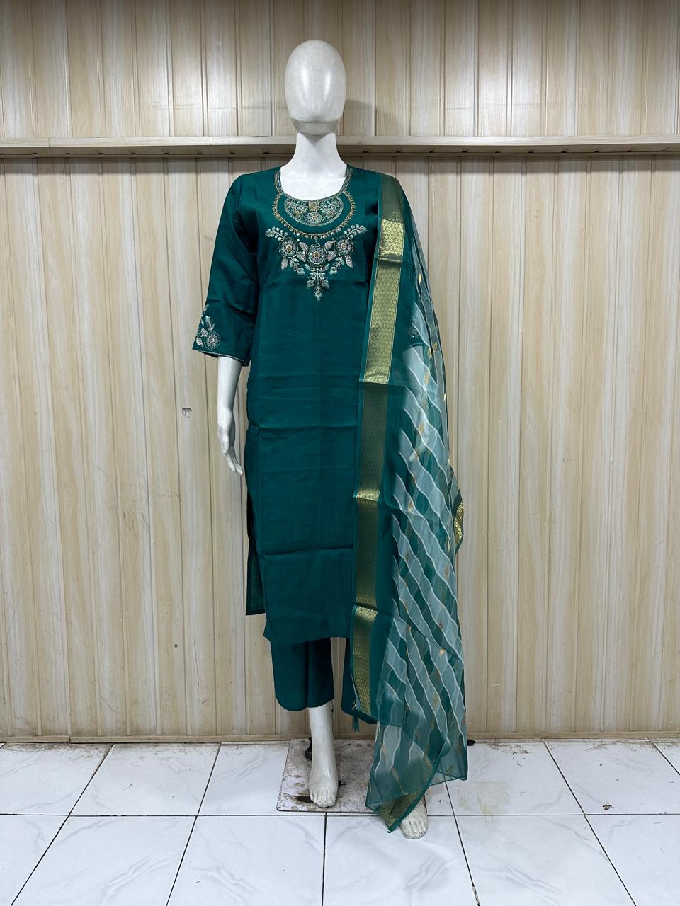 Green traditional outfit with a mannequin against a striped