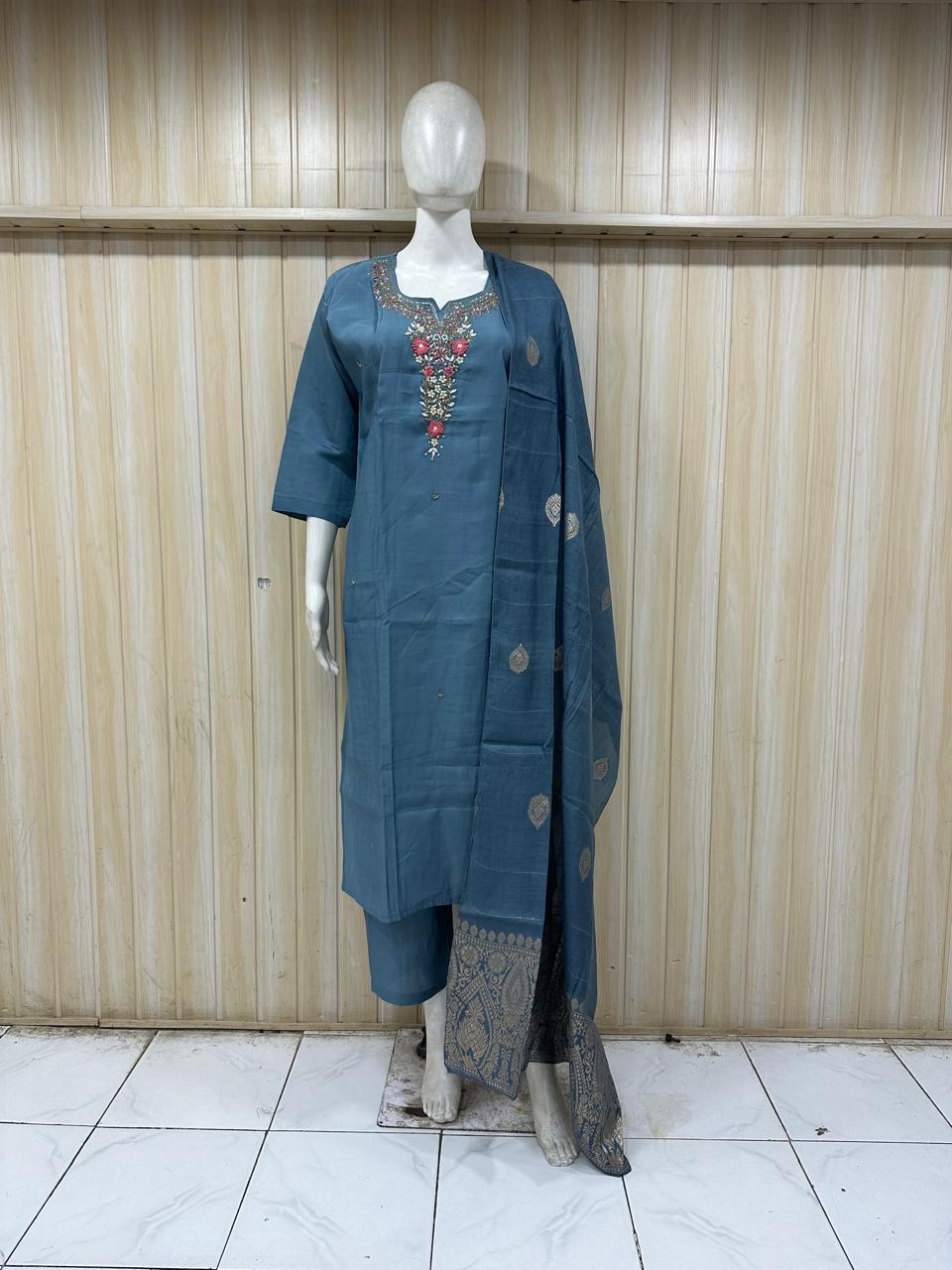 Mannequin wearing a blue traditional outfit with a dupatta against a stripedMannequin wearing a blue traditional outfit with a dupatta against a striped