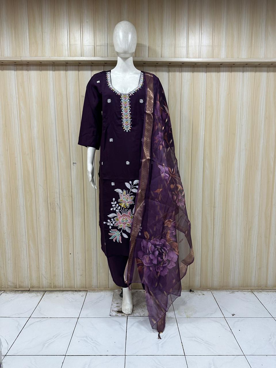 Mannequin wearing a purple embroidered dress with a matching dupatta against a striped