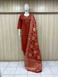 Red traditional outfit with a patterned dupatta on a mannequin against a striped
