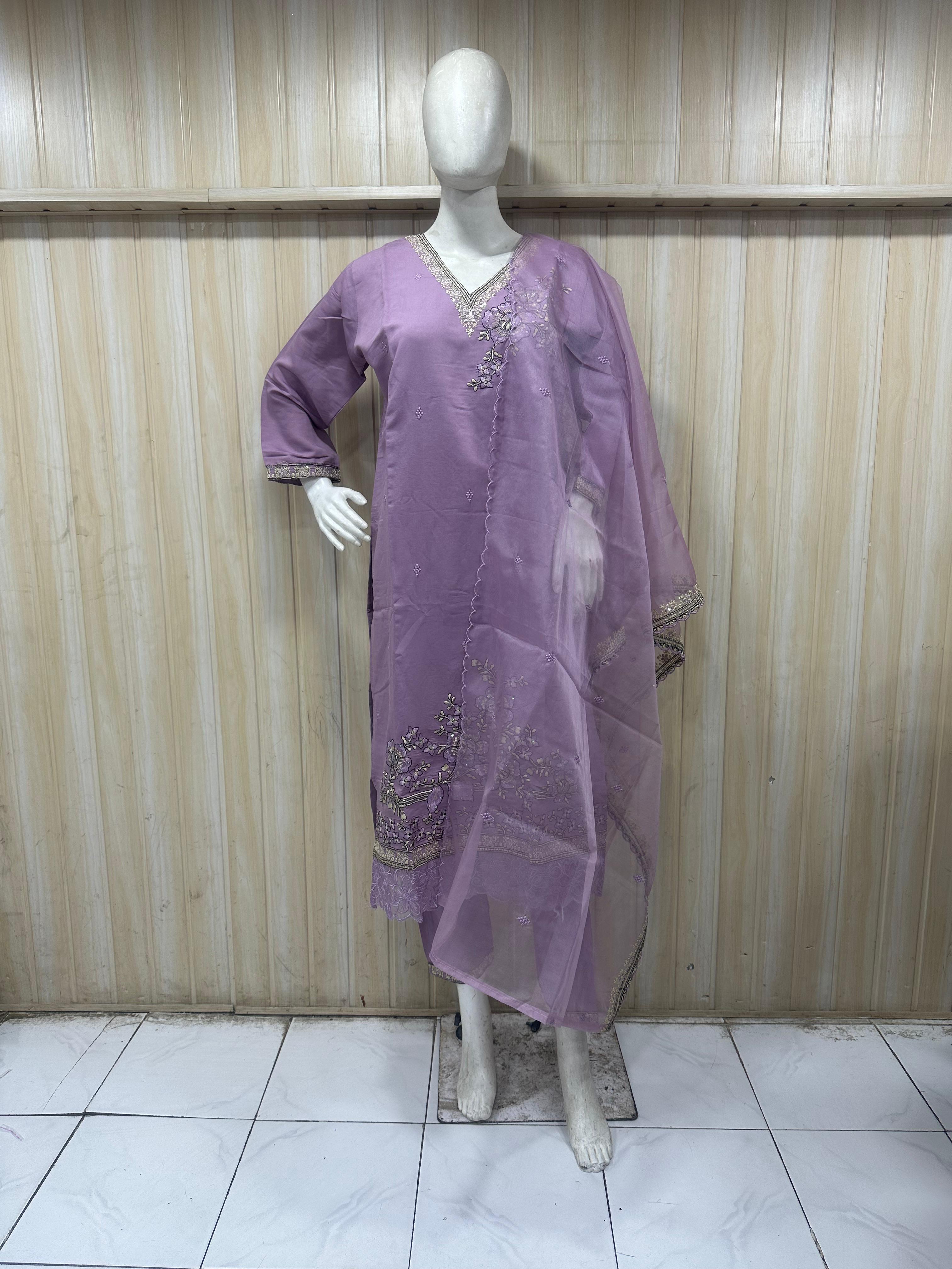 Purple dress with intricate designs on a mannequin against a striped