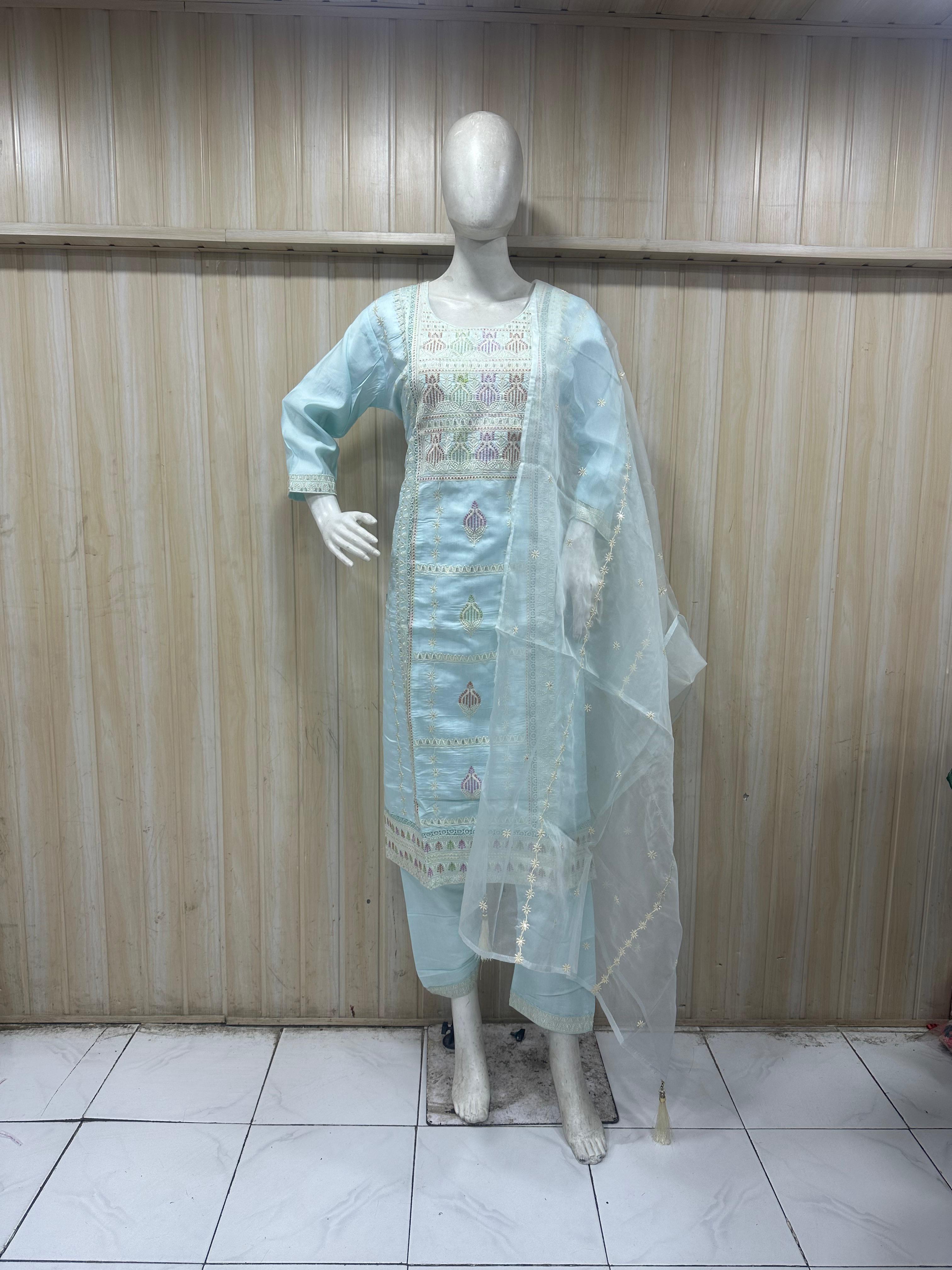 sky blue dress with intricate designs on a mannequin against a striped