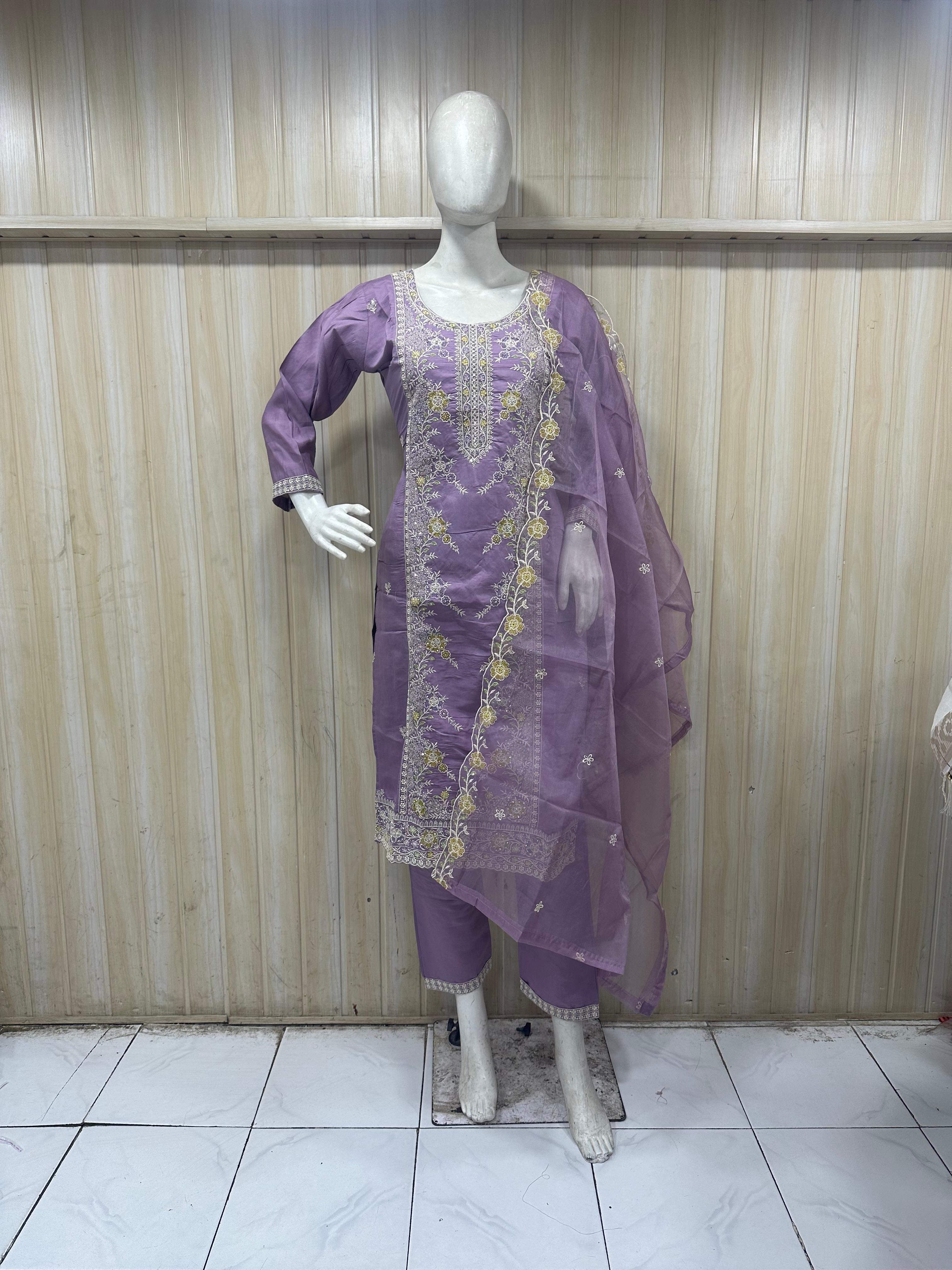 Purple embroidered traditional outfit on a mannequin against a striped