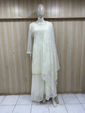 Mannequin wearing a white traditional outfit with a sheer dupatta against a wooden panel background.
