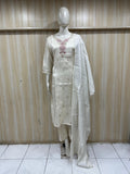 Mannequin wearing a white traditional outfit with a sheer dupatta against a wooden panel background.
