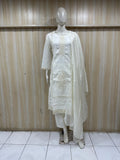 White embroidered outfit on a mannequin against a striped