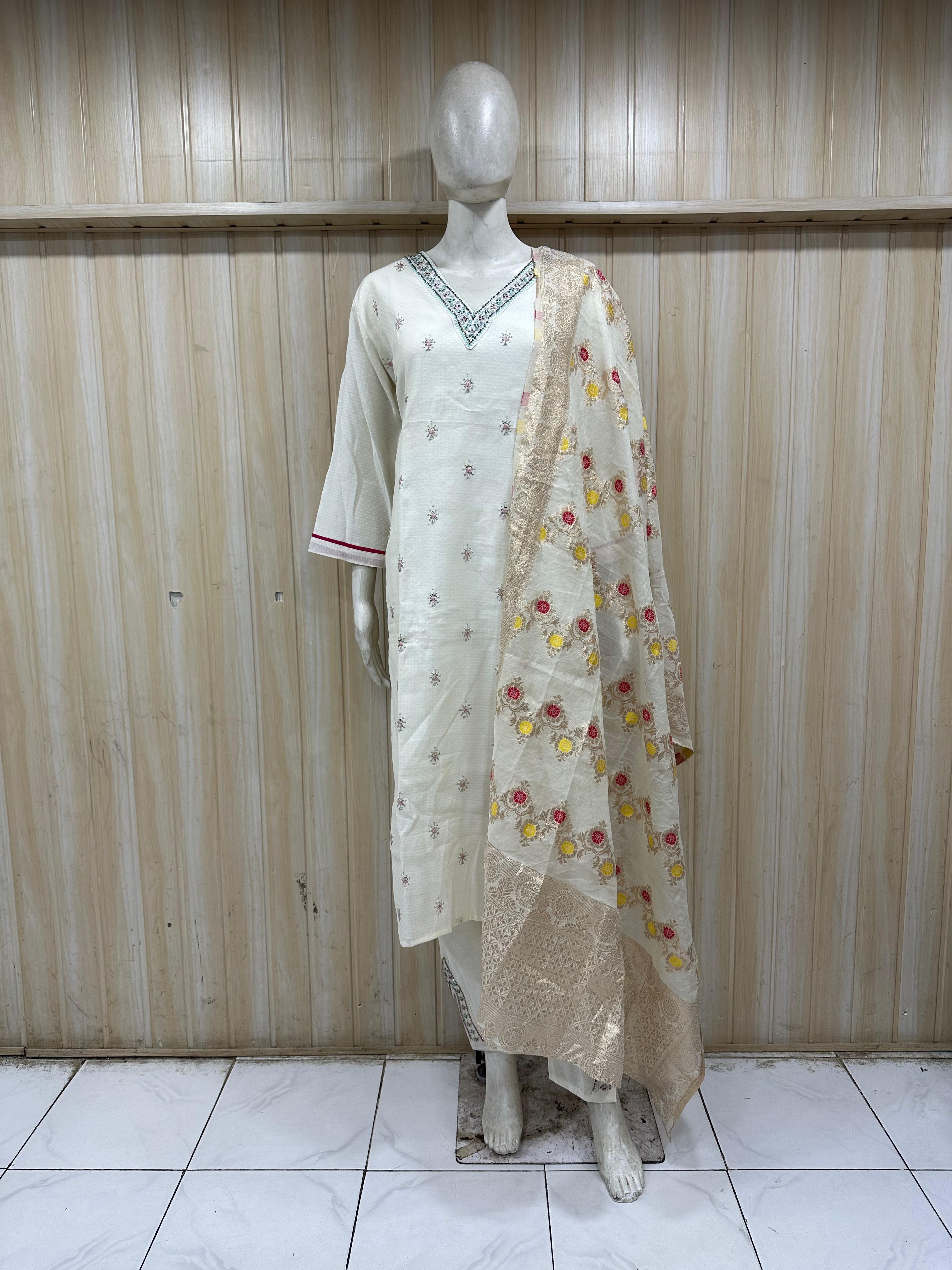 White embroidered outfit on a mannequin against a striped