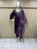Mannequin wearing a purple outfit with a matching dupatta against a wooden panel background