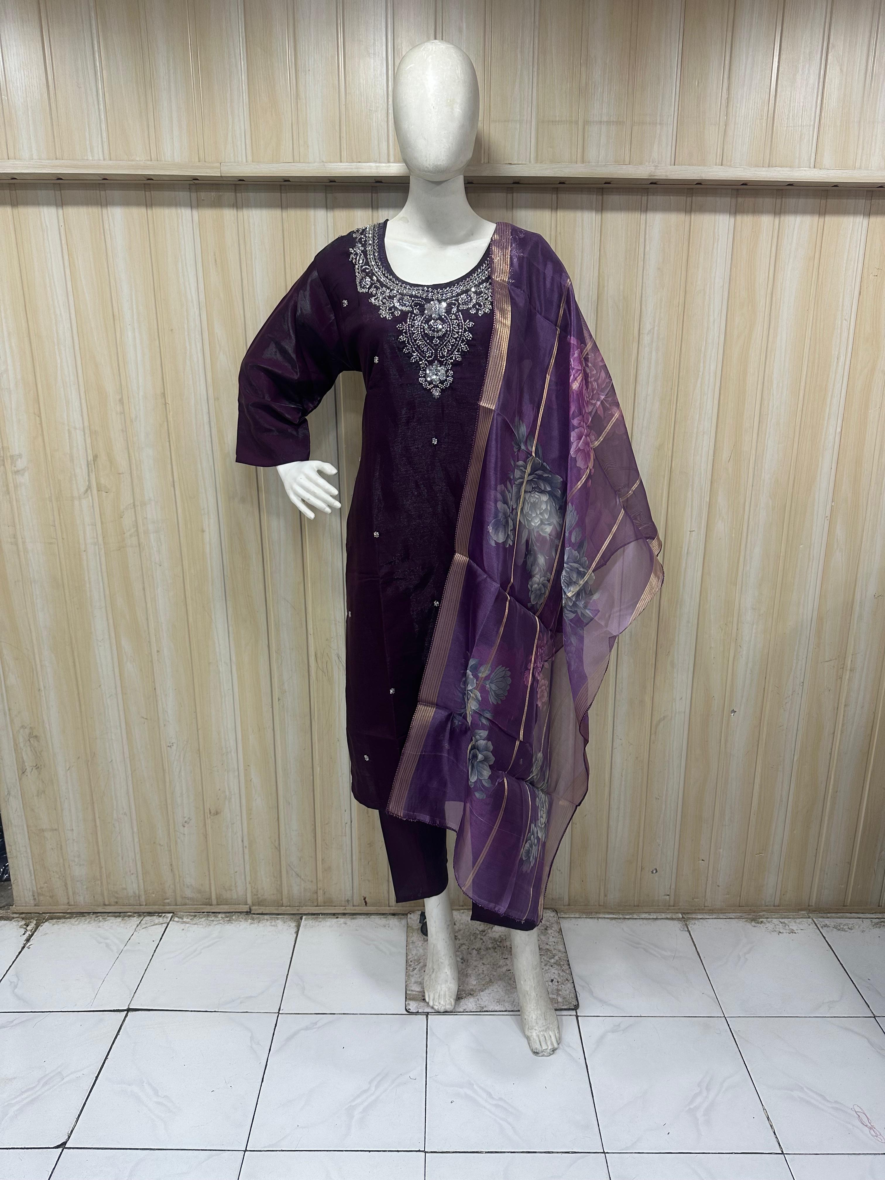 Mannequin wearing a purple outfit with a matching dupatta against a wooden panel background