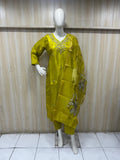 Mannequin wearing a yellow embroidered outfit against a striped