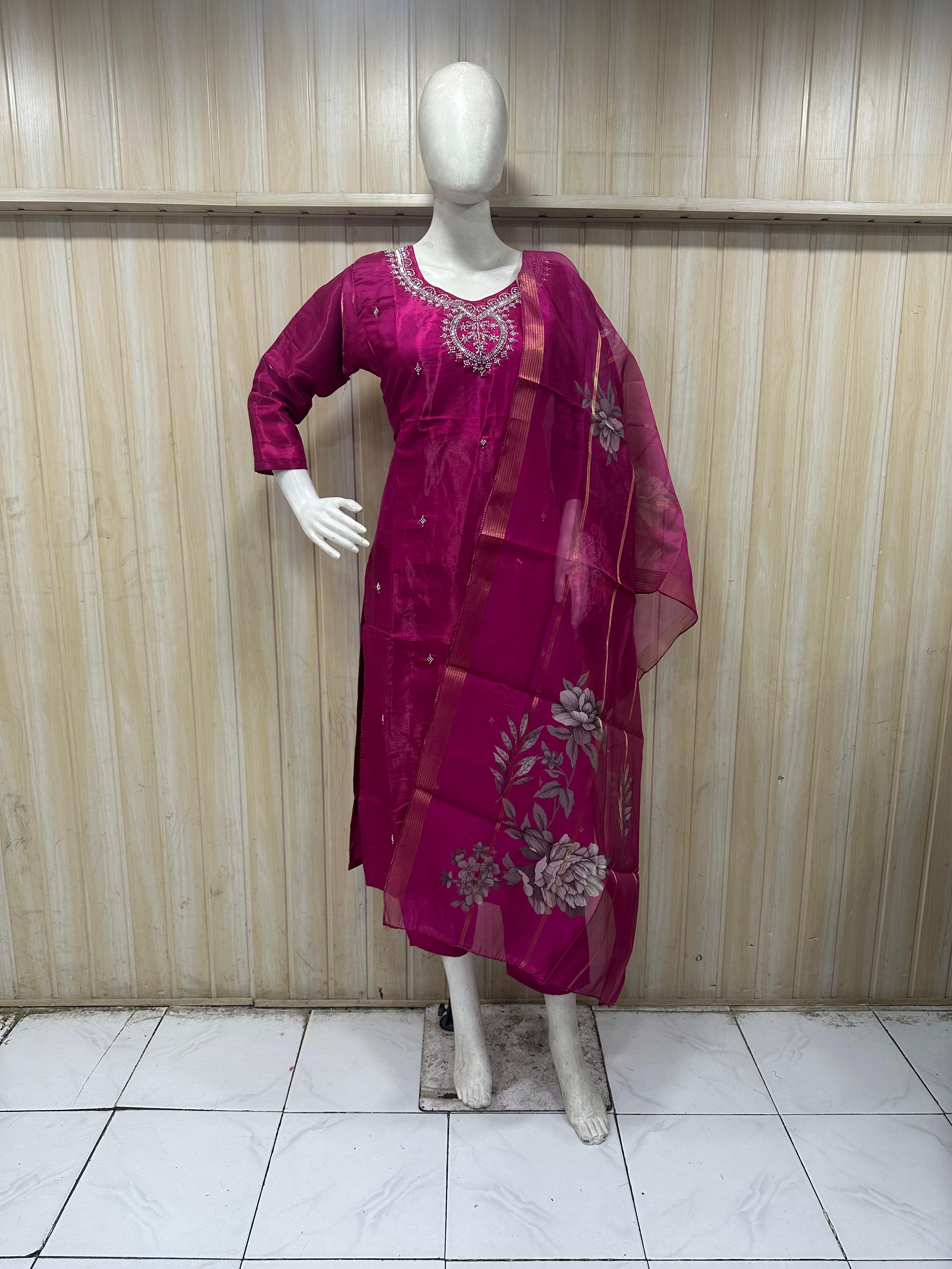 Mannequin wearing a magenta embroidered traditional outfit against a striped  ChatGPT4:05 PM
